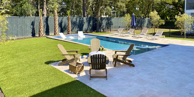 Ultra realistic and durable Fusion™ synthetic grass in a backyard pool area in Charleston