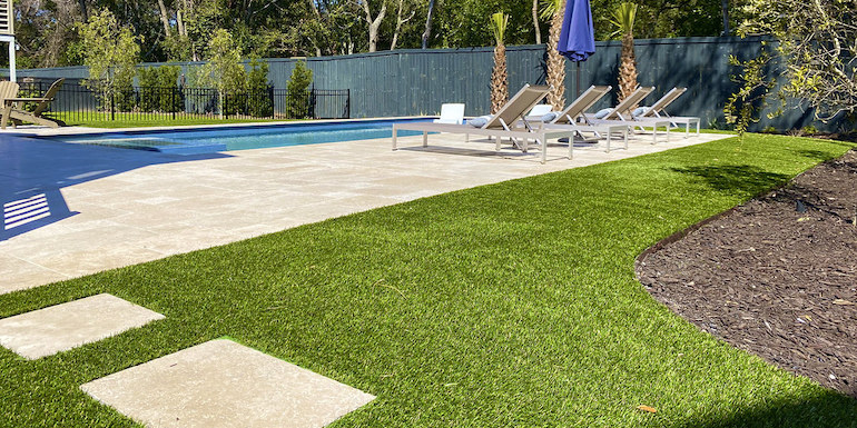 Ultra realistic and durable Fusion™ synthetic grass in a backyard pool area in Charleston